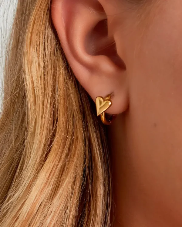 Woman wearing small gold stainless steel heart earrings | hypoallergenic, waterproof jewelry from Cutu Store Malta