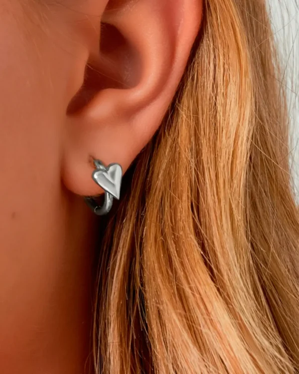 Silver heart hoop earrings worn on ear, minimalist heart jewelry by Cutu Store, exclusive in Malta.