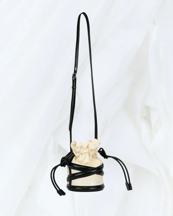 Alexander McQueen Soft Curve bucket bag in ivory and black hanging view